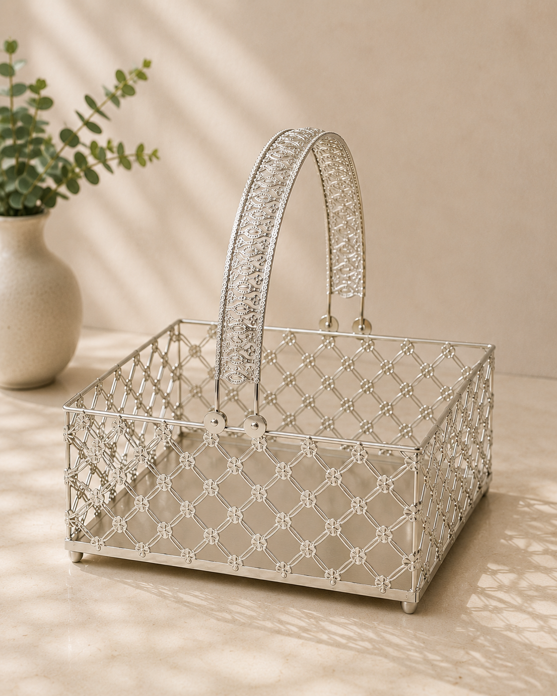 A rectangular silver metal fruit basket with an intricate lattice pattern and decorative handles, suitable for fruits, dry fruits, flowers, and premium gifting.