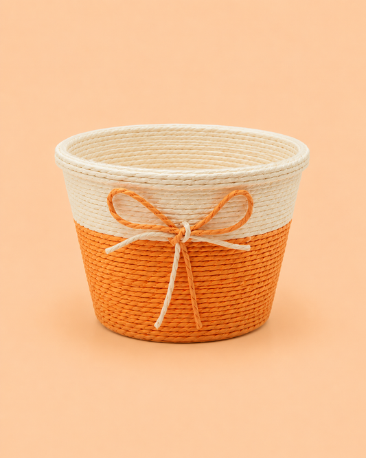 A small orange and beige woven gift basket with a decorative jute bow, ideal for chocolates, flowers, dry fruits, return gifts, and festive hamper presentations.