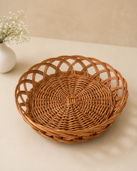 A round cane hamper basket with an open lattice weave and natural brown finish, suitable for arranging sweets, dry fruits, chocolates, flowers, and festive gifts.