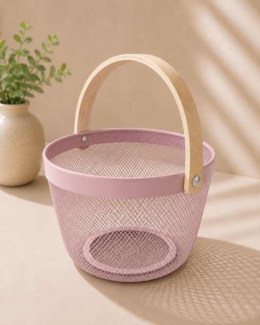 A pink round metal gift basket with a fine perforated texture and arched handle, suitable for bridal shower hampers, beauty products, candles, flowers, chocolates, and small gifts.