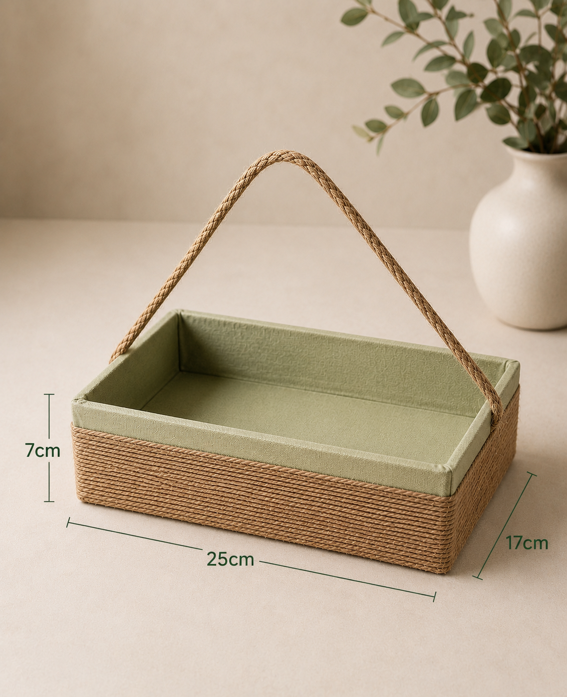 A green sutli rectangular tray with a fabric-lined interior, woven brown exterior, and braided handle, suitable for sweets, dry fruits, candles, beauty products, and curated gift hampers.