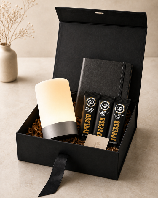 A premium black collapsible gift box featuring a touch lamp, instant coffee sachets, a black notebook, a message card, and elegant presentation for self-care and corporate gifting.