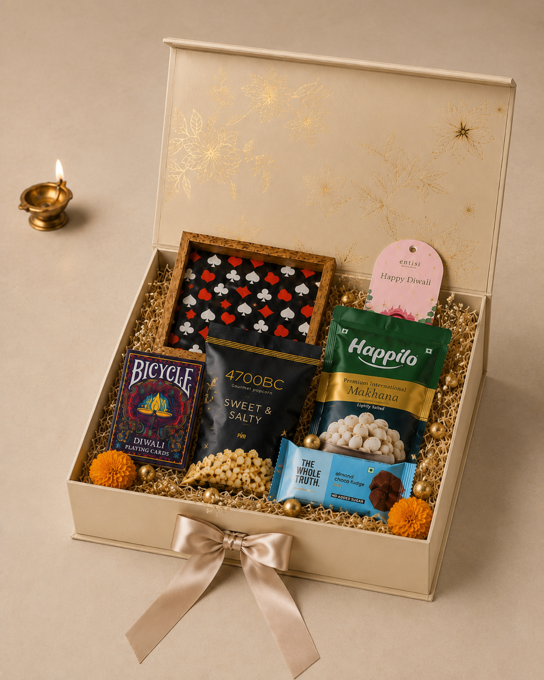 Diwali Game Night Box featuring Bicycle playing cards, a 52-card deck, popcorn, peri-peri makhana, protein bar, and Diwali greeting tag in a decorative gift box.