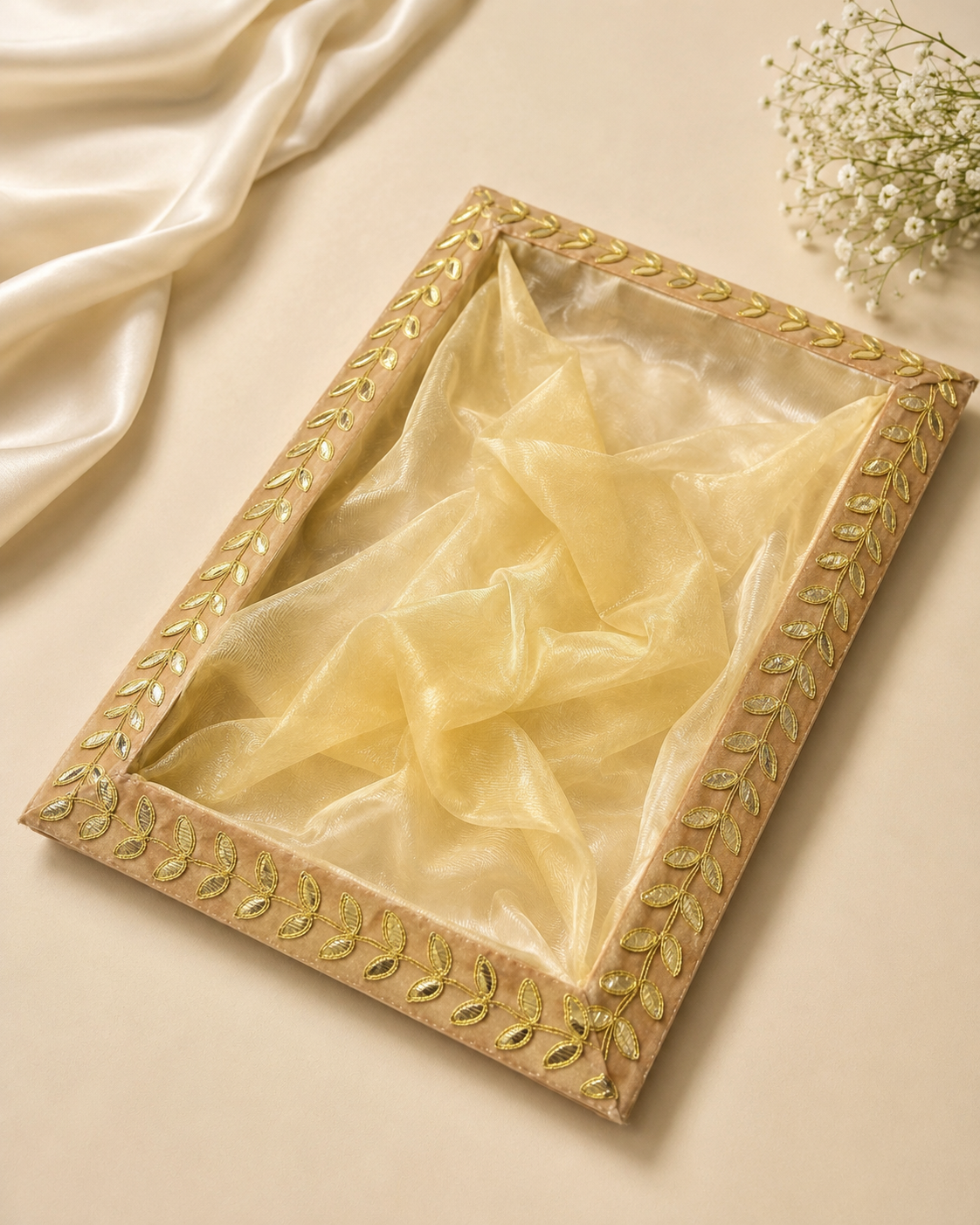 A golden gota net tray with an ornate decorative border and translucent centre, suitable for saree gifting, jewellery, sweets, dry fruits, trousseau presentations, and festive occasions.