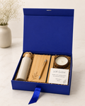 A premium blue collapsible gift box featuring an eco bottle, bamboo diary, bamboo pen, coconut shell soy candle, thank-you card, and shredded paper packaging for thoughtful corporate gifting.