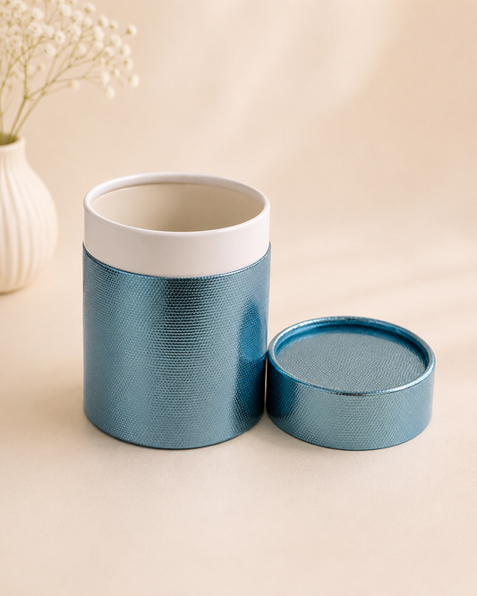 A textured blue cylindrical barrel gift box with a white interior and matching lid, designed for premium gifting, chocolates, dry fruits, candles, and curated hampers.