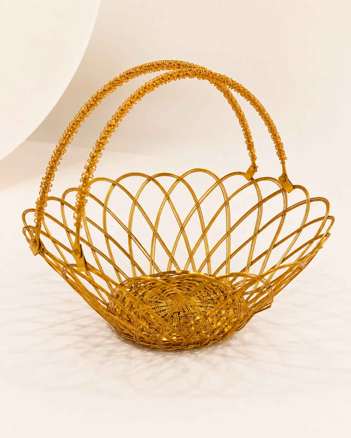 A golden flower-shaped wire tokra with curved edges and twin handles, suitable for presenting sweets, dry fruits, flowers, and festive gifts.