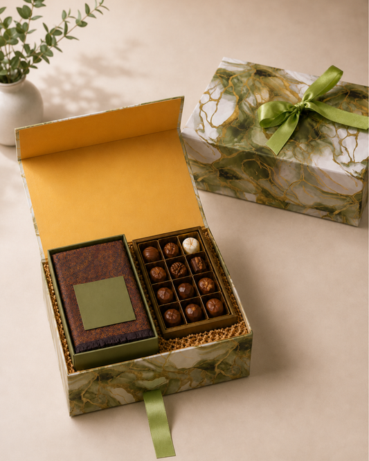 A premium marble-pattern designer gift box with a superfine unisex stole, assorted chocolates, and shredded paper packaging in a ribbon pull-out presentation.