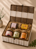 A reusable white and brown trunk basket filled with gulkand, natural honey, moringa chaas masala, paan churi, super nuts, and shredded paper for wellness gifting.