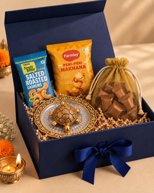 The Fortune & Flavours Box in a navy magnetic hamper box with a good luck tortoise plate, roasted cashews, peri-peri makhana, and assorted chocolates.