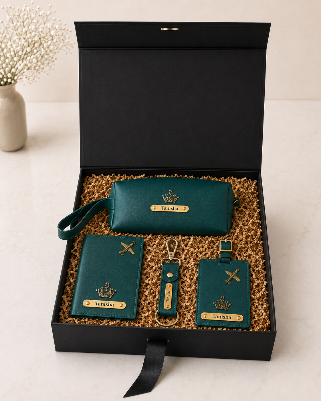 A premium black gift box featuring a personalized passport cover, utility pouch, luggage tag, keychain, and shredded paper packaging for elegant travel-themed gifting.