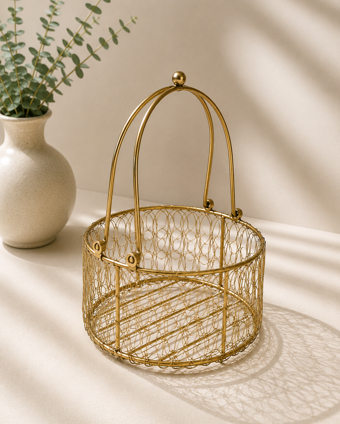 A small golden mesh basket with an intricate wire design and tall arched handle, suitable for flowers, sweets, dry fruits, festive hampers, and shagun gifting.