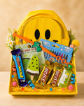A cheerful yellow smiley backpack Rakhi hamper with a kids Rakhi, crayons, stationery, chocolates, toys, and decorative packaging for festive gifting.