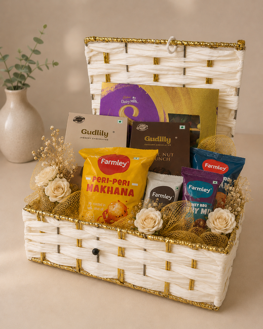 Golden Treats Trunk featuring Dairy Milk Silk, Gudlily chocolates, peri-peri makhana, Farmley snacks, and golden festive decoration in a reusable white woven trunk basket.