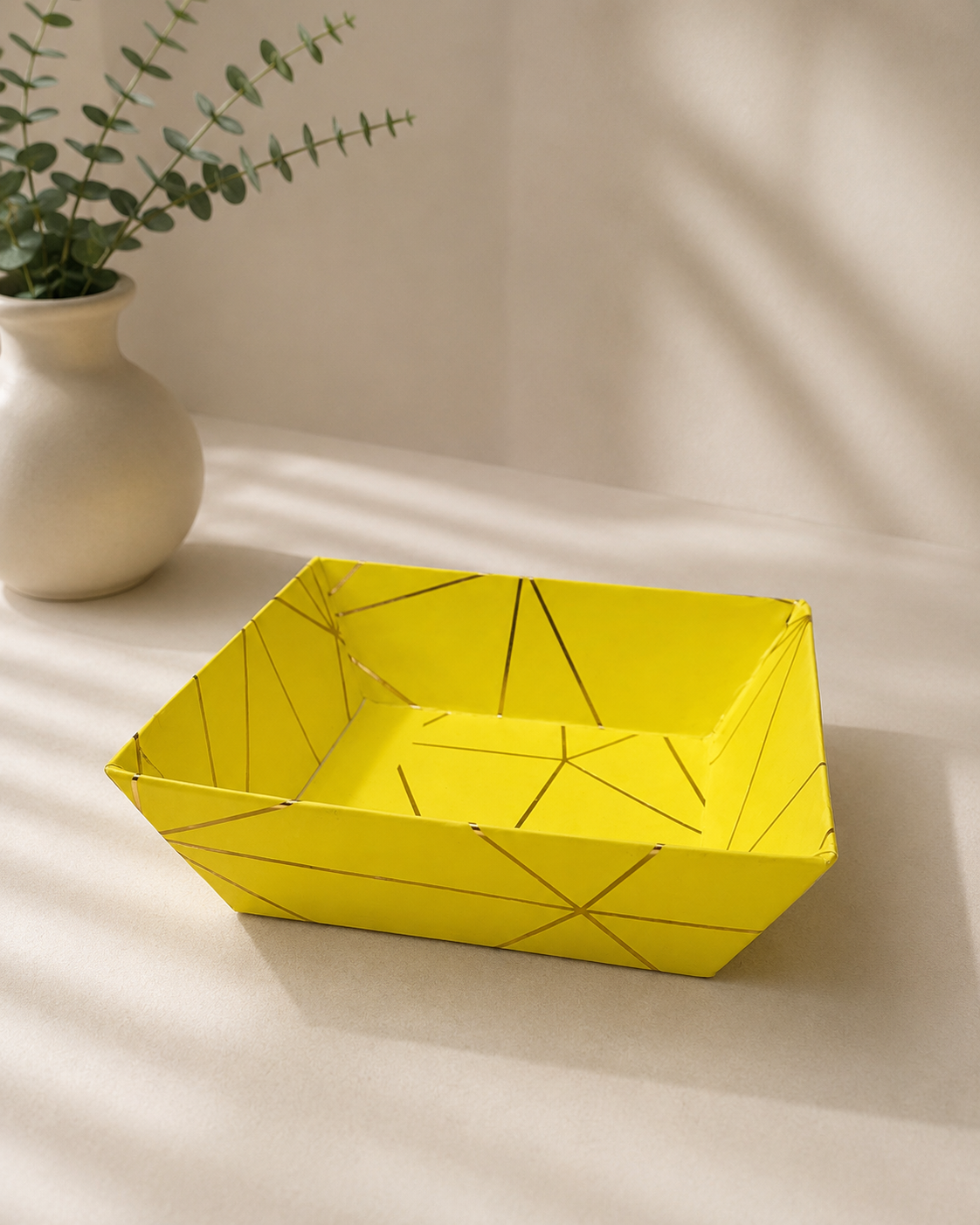 A yellow cardboard gift tray featuring a geometric printed design, suitable for arranging sweets, chocolates, dry fruits, and small festive gifts.