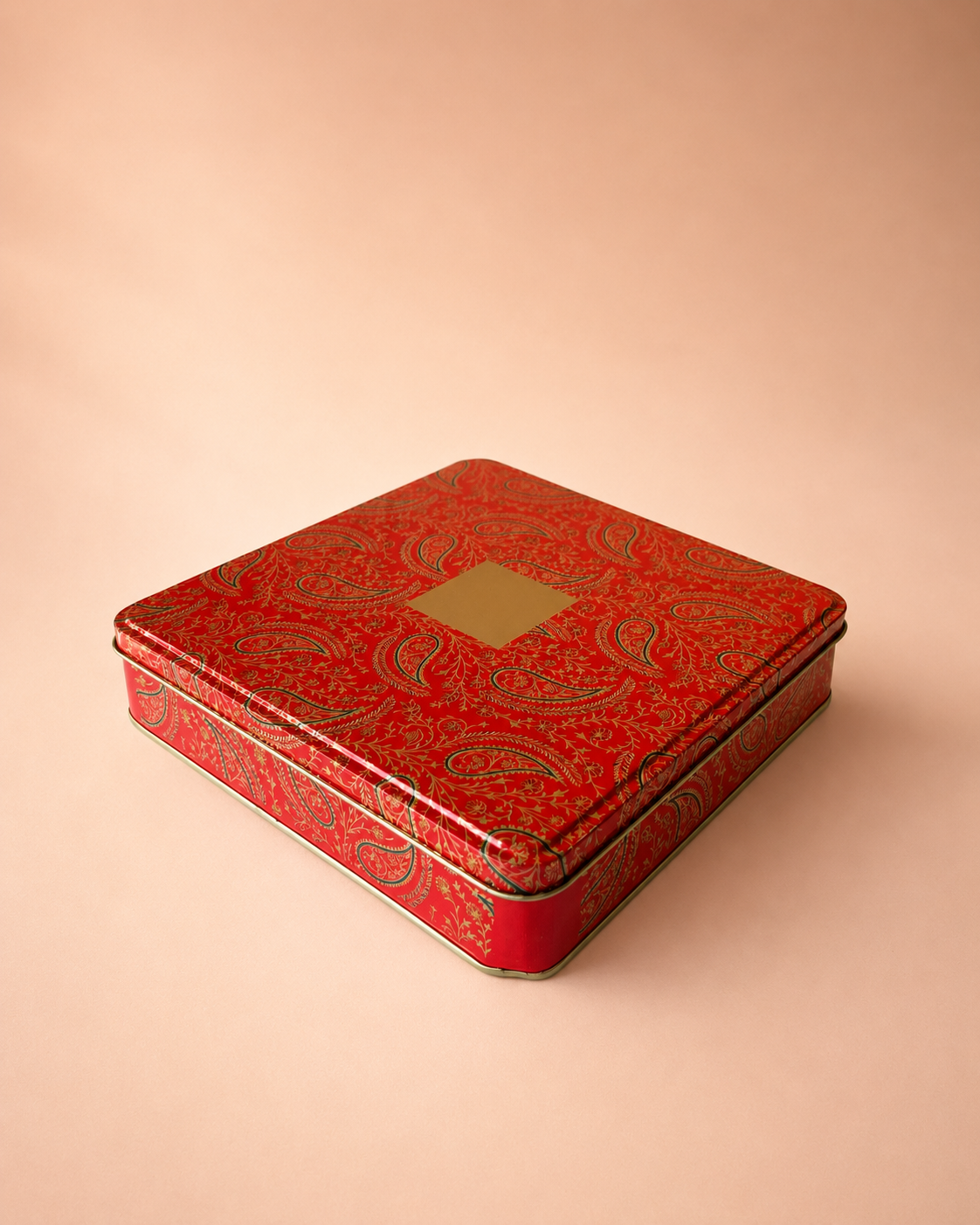 A red printed tin hamper box with an intricate ornamental pattern, green base, and fitted lid, suitable for sweets, chocolates, dry fruits, beauty gifts, and keepsakes.