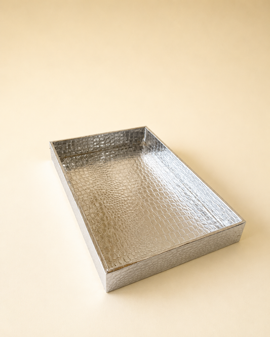 A luxurious silver rectangular tray with a textured metallic finish and raised edges, suitable for presenting sweets, dry fruits, candles, fragrances, and curated gifts.